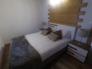 a bedroom with a bed with white sheets and pillows at Fajazinha Cottage in Faja Grande