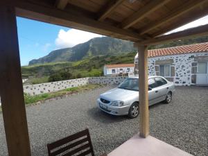 a car parked in a parking lot with a mountain in the background at Fajazinha Cottage in Faja Grande