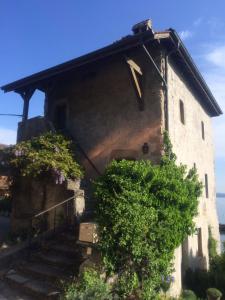 an old house with stairs leading up to it at L'Alcôve d'Amédée V in Yvoire +4 photos