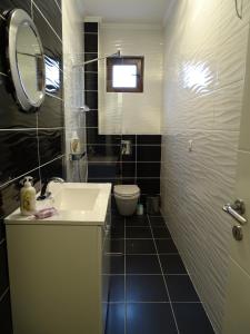 a bathroom with a sink and a toilet and a mirror at Motel Luxor in Visoko