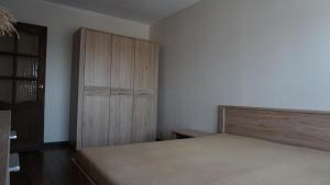 una camera con letto e armadio in legno di Sunny Ventspils 7 a Ventspils