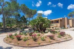 a garden with flowers in front of a building at Ses Eufabietes Apartments & Restaurant in Sant Francesc Xavier +20 photos