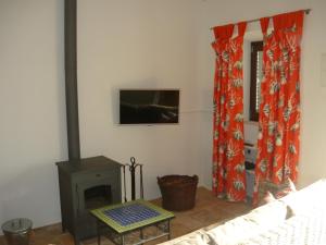 a living room with a fireplace and a tv at Casa do Gato in Ferragudo