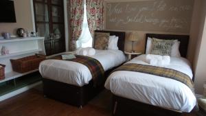 a bedroom with two beds and a sign on the wall at Hooray Henrys in Sheringham