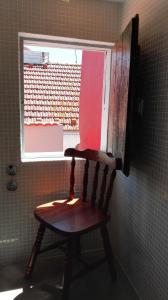 リスボンにあるNew incredible triplex in the very heartの窓付きの客室内の木製椅子