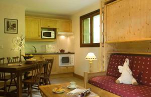 a kitchen and a living room with a couch and a table at Résidence Tournette in Le Grand-Bornand