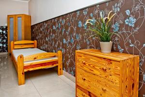 ブワディスワボボにあるGdańska19の木製ドレッサーと鉢植えの植物が備わるベッドルーム1室