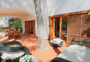 un patio con un árbol, sillas y una mesa en Ville Campo Verde by TerraSalento, en San Cataldo