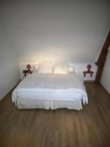 een slaapkamer met een wit bed en 2 bijzettafels bij Gite a la Ferme - Baie de Somme in Saint-Quentin-Lamotte-Croix-au-Bailly