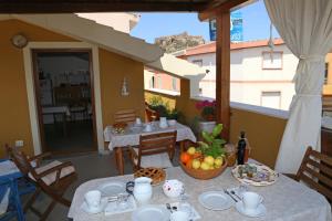 a table with plates of food on a balcony at Il Tramonto in Castelsardo