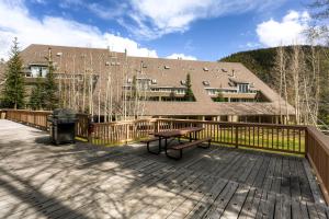 a deck with a picnic table and a building at Evergreen Condominiums by Keystone Resort in Keystone