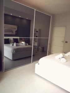 a bedroom with two beds and a large mirror at La Casa del Sole in Cinisi