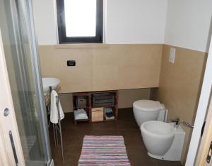 a bathroom with a toilet and a sink and a window at Aspromontando in Polistena