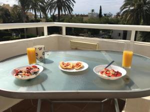 three plates of food on a table on a balcony at Arabella Naturist Apartment in Vera
