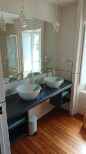 a bathroom with two sinks and a large mirror at Le 29 d'à côté in Pont-Croix