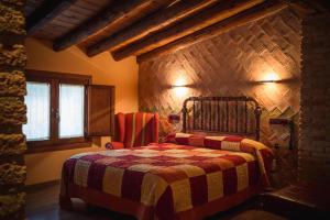 a bedroom with a bed in a stone wall at A Corona del Reino in Ejea de los Caballeros