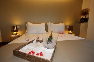 a tray of wine glasses and wine bottles on a bed at Sintra Boutique Hotel in Sintra