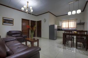 a living room with a couch and a table and a kitchen at Royal Mansion in Paramaribo +10 photos