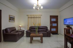 een woonkamer met 2 leren banken en een tafel bij Royal Mansion in Paramaribo
