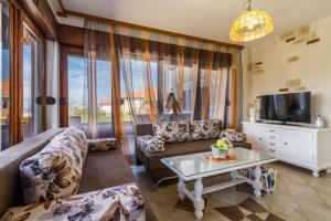 a living room with a couch and a tv at Villa Domic in Slatine