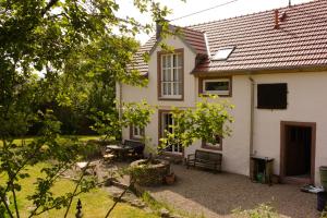 a small white house with a yard with trees at Ferienhaus Vulkaneifel Landhaus Loogh in Kerpen