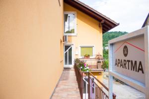 a yellow building with a balcony and a sign at Pri Neji in Postojna