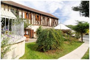 una casa con un arbusto delante de ella en La Ferme des Grisettes, en Montesquiou