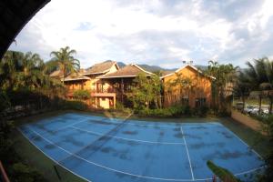 a tennis court in front of a house at Ilhabela Flat in Ilhabela