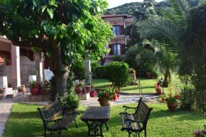 a park with benches and a table in the grass at House Evristhenis 1 in Toroni