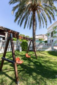 un columpio en un patio con una palmera en Chalet Villadulce, en Aguadulce