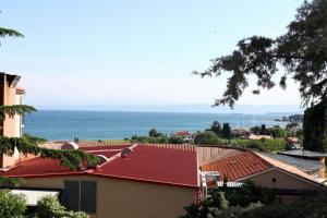 een gebouw met een rood dak met de oceaan op de achtergrond bij Trendy Apartment Izola JS in Izola