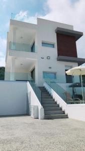 un edificio bianco con scale e tavolo e ombrellone di Villa Spathele a Paralimni