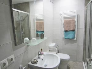 a white bathroom with a sink and a toilet at Botic4 in Cádiz