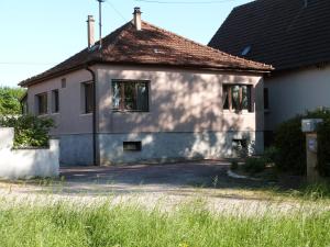 een wit huis met een zwart dak bij la maison de Lucie in Surbourg