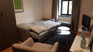 a small living room with a bed and chairs at The Gusto apartmán in Chomutov