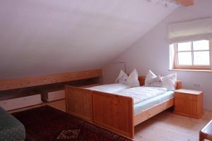 Schlafzimmer mit einem Bett mit weißer Bettwäsche und Kissen in der Unterkunft Biohof Schmidbauer in Frankenburg