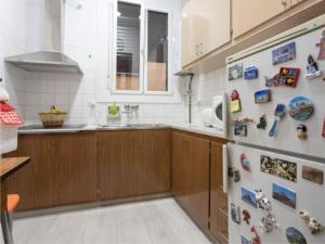 a kitchen with wooden cabinets and a refrigerator with magnets at Apartamento Céntrico in Ripoll