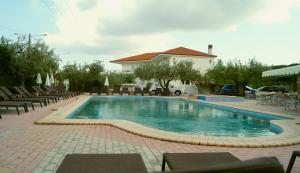 a large swimming pool with chairs and a building at Bella Grecia in Hanioti