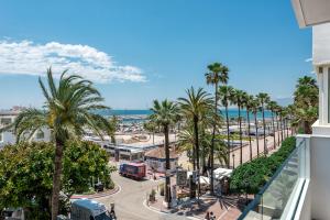 uitzicht op een straat met palmbomen en de oceaan bij Marbella Luxury Frontline Beach W Panoramic View in Marbella