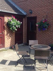 a patio with a table and chairs and flowers at The Farmhouse B&B in Goole