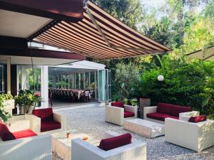 un patio con divani, sedie e tavolo di Hotel Adriaco a Grado