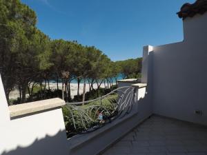 a balcony with a bench and a view of the beach at La Corte degli Ulivi Appartamenti in Cala Liberotto