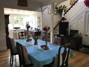 a dining room with a blue table with flowers on it at Coombe Lodge Farm House in Bristol