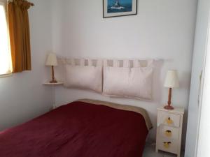 - une chambre avec un lit avec un couvre-lit rouge et deux lampes dans l'établissement Résidence Hameau du Soleil, à Valras-Plage