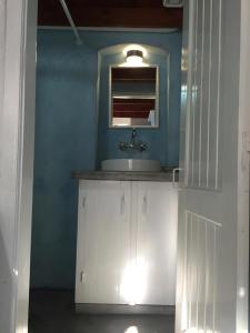 ein Bad mit einem Waschbecken und einem Spiegel in der Unterkunft Plesner House, Symi Greece in Symi