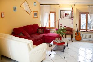 a living room with a red couch and a guitar at Porta Marina in Recanati