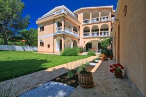 a large house with a large yard with plants at Sun Palace Residence in Premantura