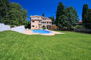 a house with a large yard with a swimming pool at Sun Palace Residence in Premantura