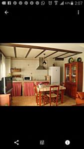 a kitchen and dining room with a table and a refrigerator at Rincón del Valle del Jerte in Navaconcejo +42 photos