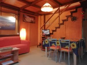 a living room with a table and chairs and a couch at Casa Etna-Mare in Santa Venerina